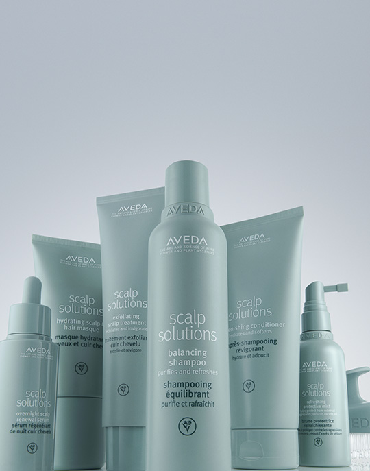 A group of Aveda Scalp Solutions hair care products, including shampoo, conditioner, serums, and treatments for optimal scalp health, arranged upright against a light background. | AMORE Salon, St. Petersburg, FL